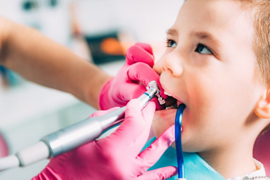 Child dentistry. Female dentist working with school boy